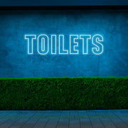 ice blue toilets neon sign hanging on outdoor wall