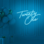 ice blue  twenty one neon sign hanging on wall with balloons