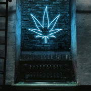 ice blue weed leaf neon sign hanging on bar wall