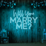 ice blue will you marry me neon sign hanging on timber wall