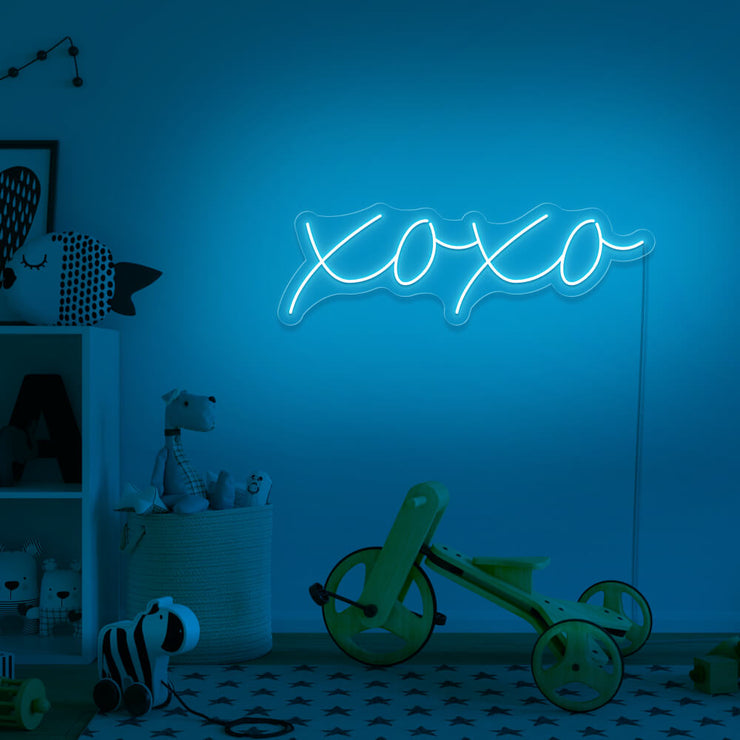 ice blue xoxo neon sign hanging on kids bedroom wall