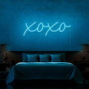 ice blue xoxo neon sign hanging on bedroom wall