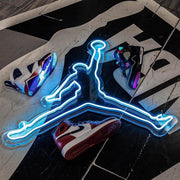blue jordan jumpman neon sign placed on floor around jordan sneakers