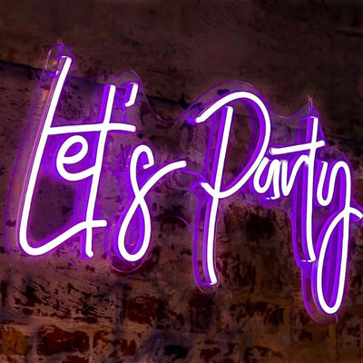 purple lets party neon sign hanging on brick wall