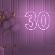 light pink 30 neon sign hanging on wall with balloons
