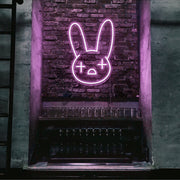 light pink bad bunny neon sign hanging on bar wall