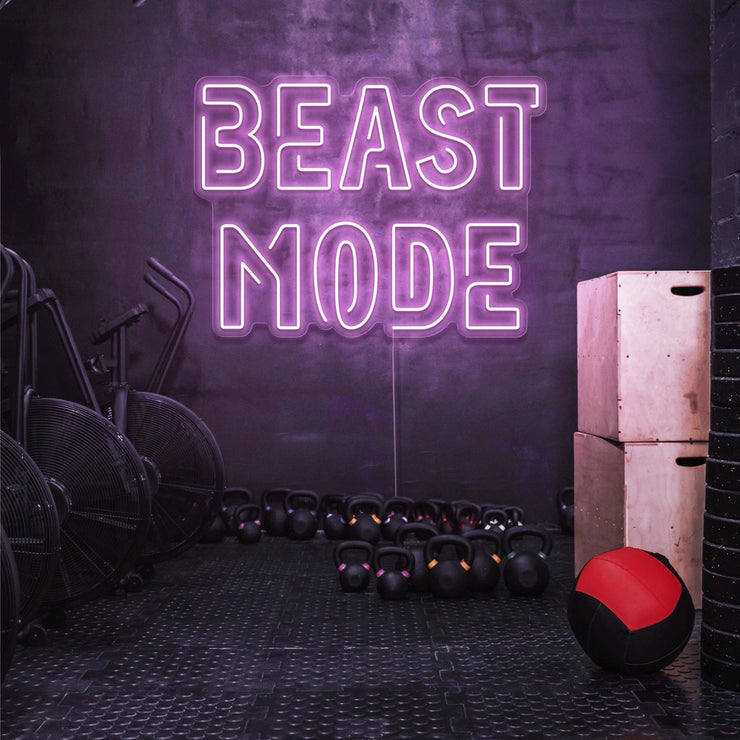 light pink beast mode neon sign hanging on gym wall
