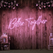 light pink better together neon sign hanging on timber wall