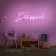 light pink blessed neon sign hanging on kids bedroom wall