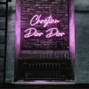 light pink christian dior dior neon sign hanging on bar wall