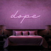 light pink dope cursive neon sign hanging on bedroom wall