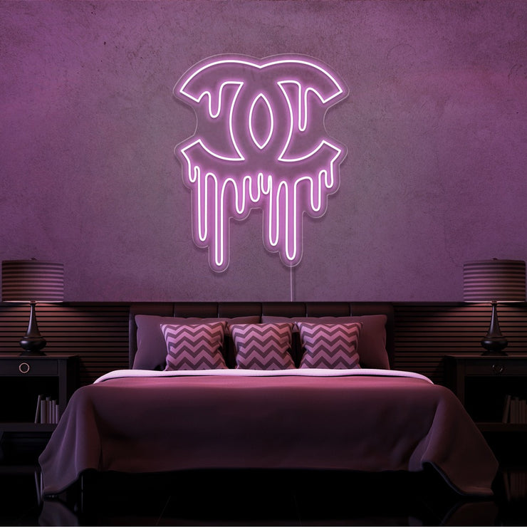 light pink dripping chanel neon sign hanging on bedroom wall