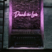 light pink drunk in love neon sign hanging on bar wall