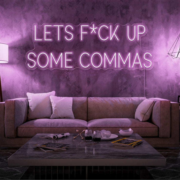 light pink lets fuck up commas neon sign hanging on living room wall