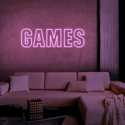 light pink games neon sign hanging on games room wall