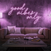 light pink good vibes only neon sign hanging on living room wall