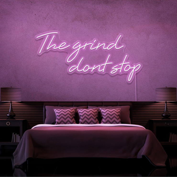 light pink the grind dont stop neon sign hanging on bedroom wall
