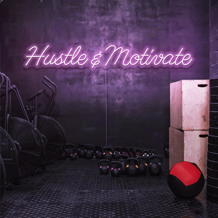 light pink hustle and motivate neon sign hanging on gym wall