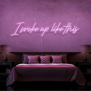 light pink i woke up like this neon sign hanging on bedroom wall