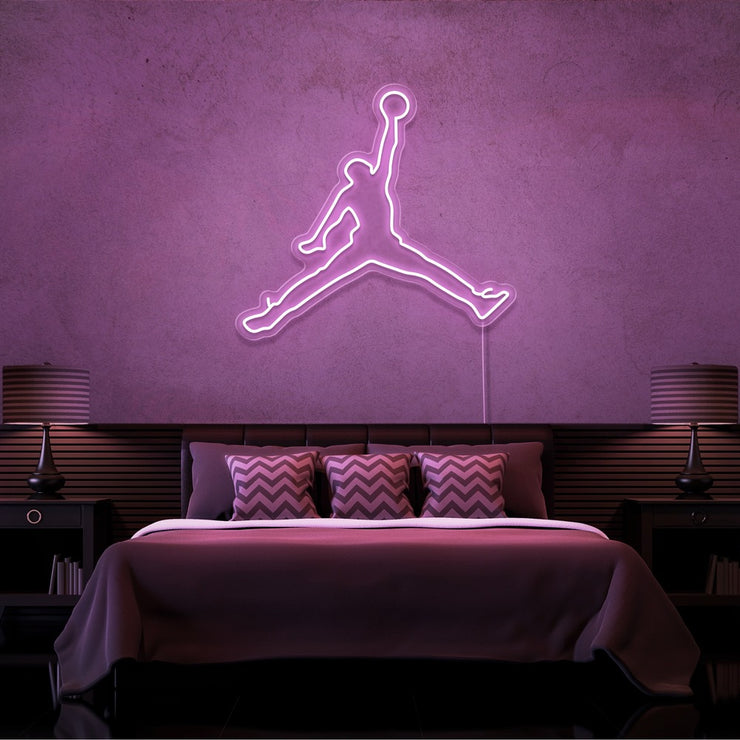light pink jordan jumpman neon sign hanging on bedroom wall