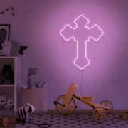 light pink cross neon sign hanging on kids bedroom wall