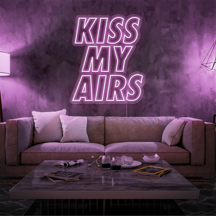 light pink kiss my airs neon sign hanging on living room wall