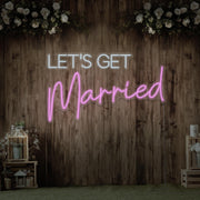 light pink lets get married neon sign hanging on timber wall