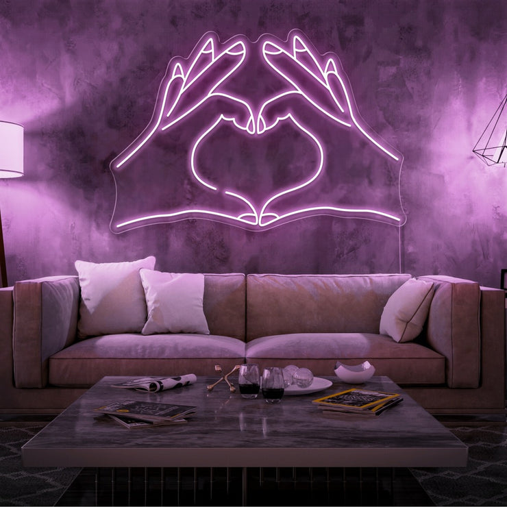 light pink love hands neon sign hanging on living room wall
