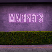 light pink markets neon sign hanging on outside wall