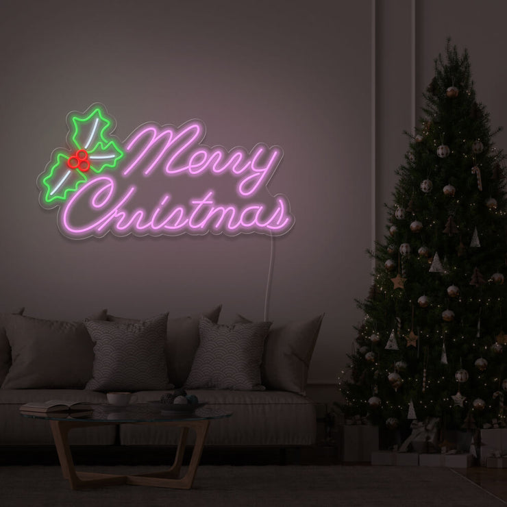 light pink merry chirstmas mistletoe neon sign hanging above couch next to christmas tree