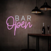 light pink open bar neon sign hanging on bar wall