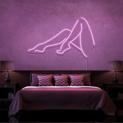 light pink sexy legs neon sign hanging on bedroom wall