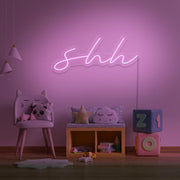 light pink shh neon sign hanging on kids bedroom wall