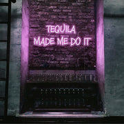 light pink tequila made me do it neon sign hanging on bar wall