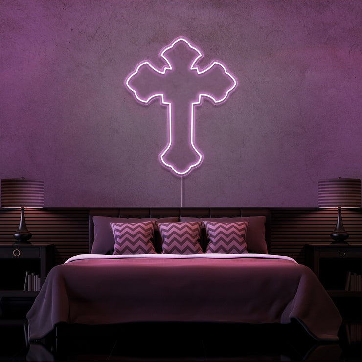 light pink tupac cross neon sign hanging on bedroom wall