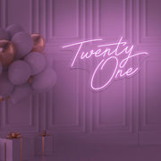 light pink  twenty one neon sign hanging on wall with balloons