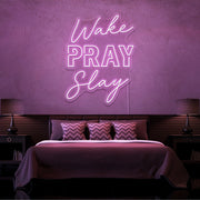 light pink wake pray slay neon sign hanging on bedroom wall