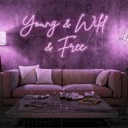 light pink young and wild and free neon sign hanging on living room wall