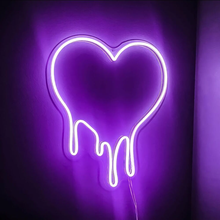purple melting heart neon sign hanging on wall