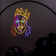 multicoloured biggie neon sign hanging on black mesh backdrop frame with balloons