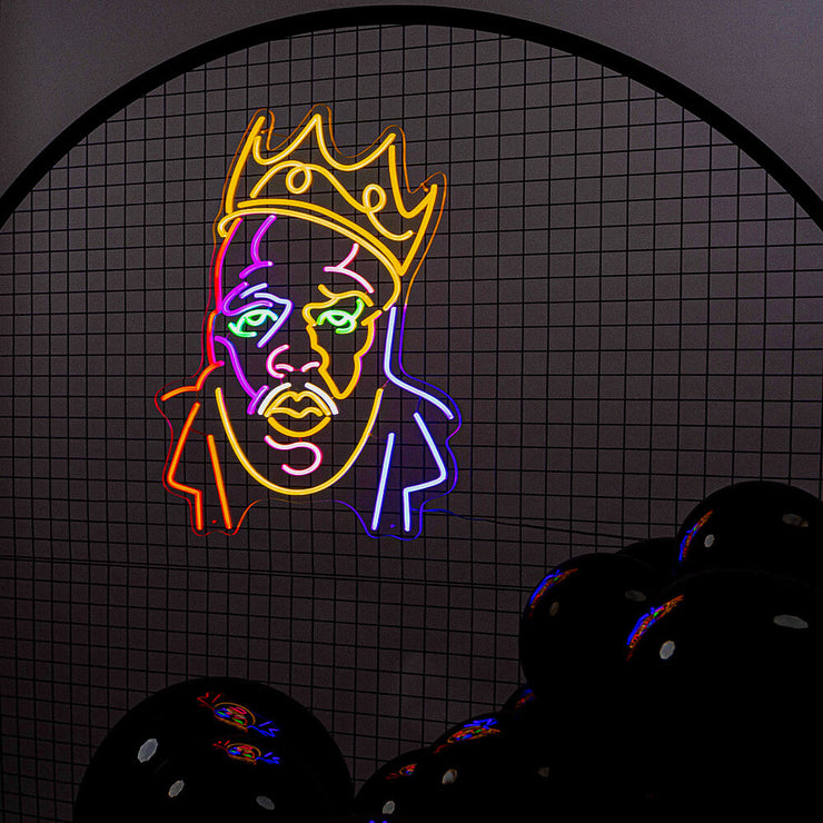 multicoloured biggie neon sign hanging on black mesh backdrop frame with balloons