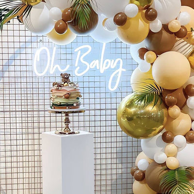 oh baby neon sign hanging on gold mesh backdrop frame with balloons