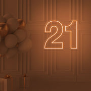orange  21 neon sign hanging on wall with balloons