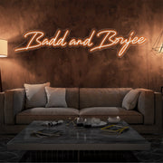 orange bad and boujee neon sign hanging on living room wall