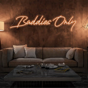 orange baddies only neon sign hanging on living room wall