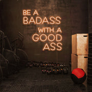 orange be a badass with a good ass neon sign hanging on gym wall