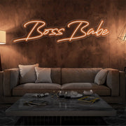 orange boss babe neon sign hanging on living  room wall