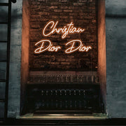 orange christian dior dior neon sign hanging on bar wall