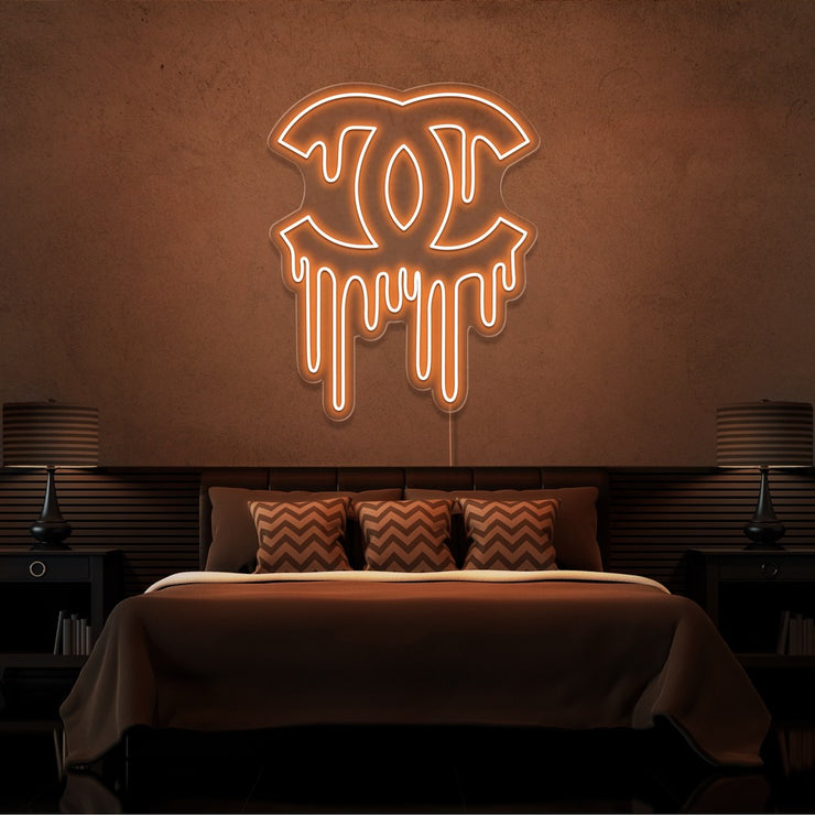 orange dripping chanel neon sign hanging on bedroom wall
