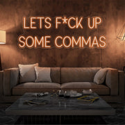 orange lets fuck up commas neon sign hanging on living room wall